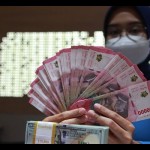 Petugas perbankan menunjukkan uang dolar AS dan uang rupiah, Jakarta, Selasa (31/1/2023). (ANTARA FOTO/Reno Esnir/tom/aa)-1694068959